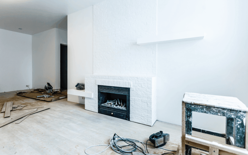 Reforma interior de vivienda con chimenea renovada y trabajos de acondicionamiento en proceso.